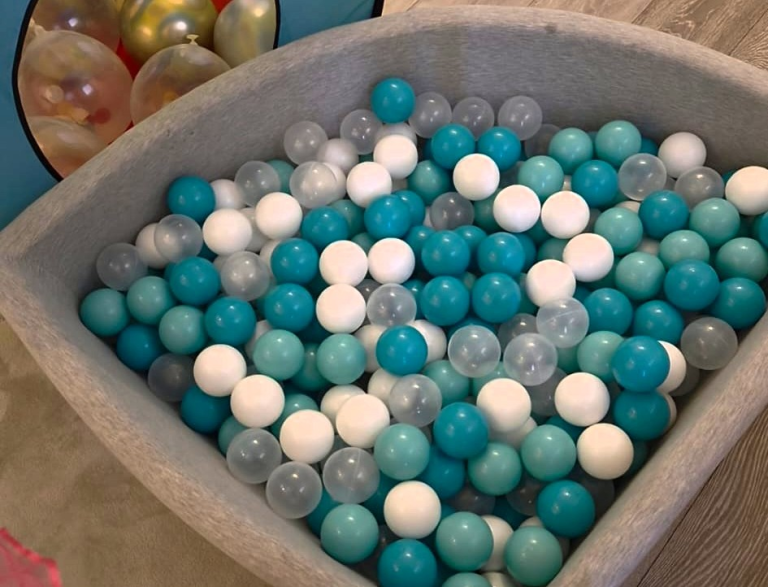 Bällebad Krabbelwiese Baden-Baden Bunte, runde Kugeln in Blau, Weiß und Transparent in einer Schüssel.