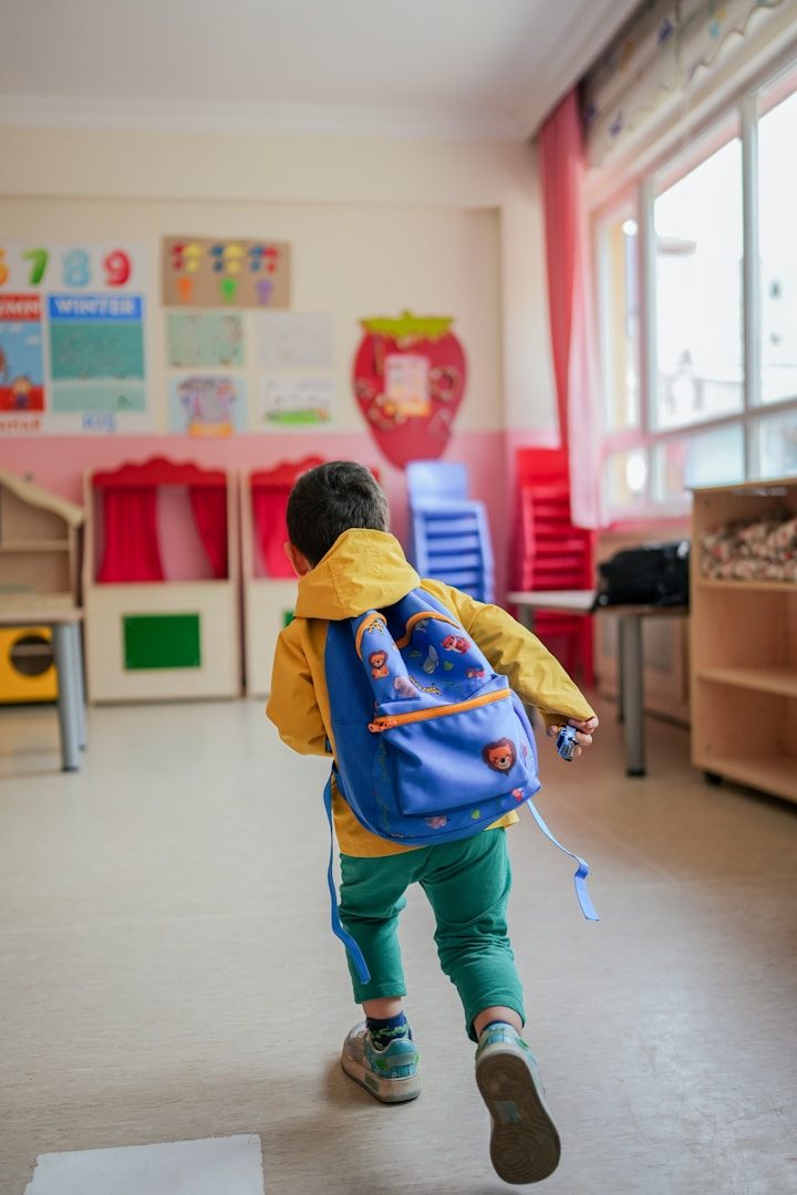 Entwicklungsbegleitung Ortsunabhängig Krabbelwiese Baden-Baden Ein Kind mit Rucksack läuft in einem Klassenraum mit bunten Möbeln.